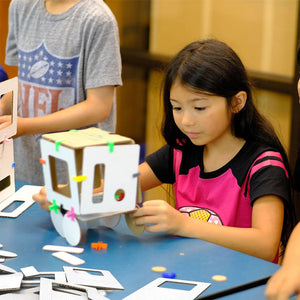 elementary school girl learning STEM with cardboard and connector modeling set