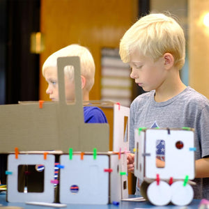 elementary school children learning STEAM with cardboard and connector modeling set